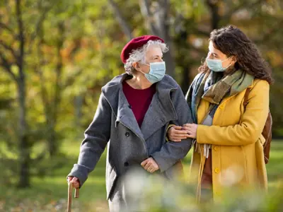 Grandma and Granddaughter wearing masks walking outside