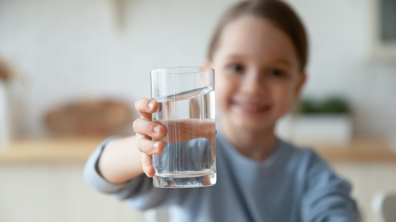 Young girl holding glass of water