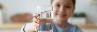 Young girl holding glass of water