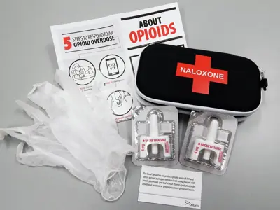 Open naloxone kit on a white table.