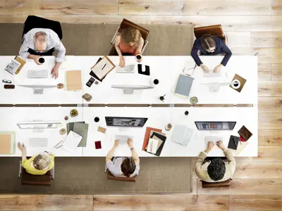 People sitting across from each other at a desk on computers