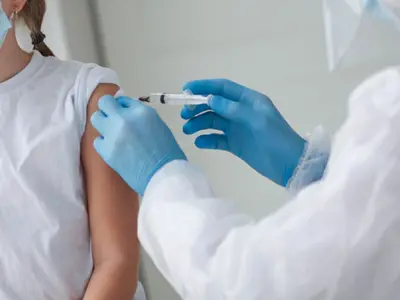 Gloved Hand Giving Vaccine In Arm