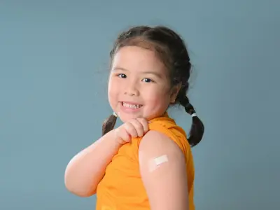 Child smiling with band-aid on arm