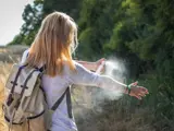 Girl applying bug repellant while outdoors