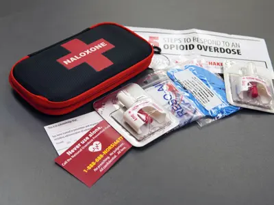 Naloxone kit and contents on a table top.