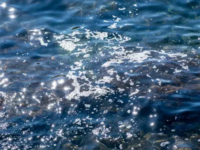 Close up of waves near the shore with pollution.