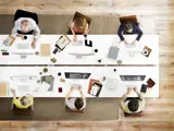 Overhead photo of people working around a table in a meeting.