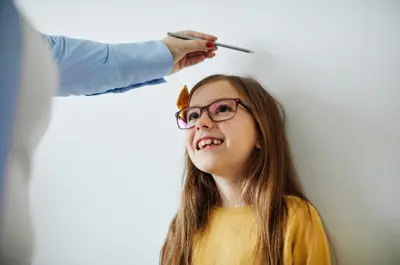 Child's height being measured by a parent.