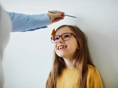 Child's height being measured by a parent.