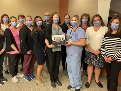 Image of Dr. Bocking handing a plaque to staff.  